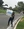 Associate Vice President for Student Life Marjorie Robinson waves a congratulatory sign as graduates drive by. 