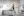An installation space at La Sierra University Brandstater Gallery by Brittany Mojo, with minimalist drawings covering all walls. The room's center has wooden sawhorses and scattered items, adding a workshop vibe, while a shelf above holds bottles and a plant, contrasting with the clean, ordered art display