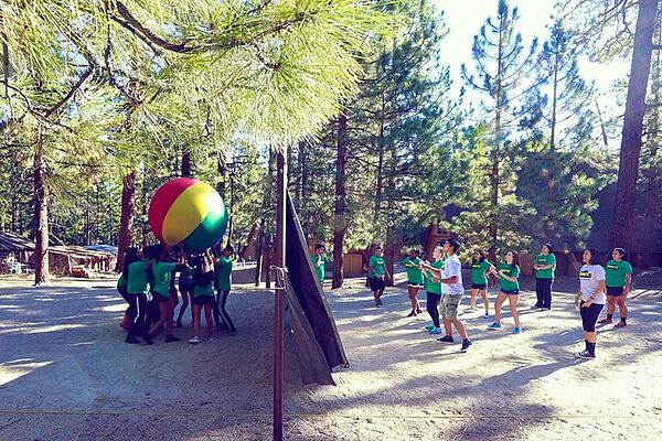 Playing earth volleyball under the pines. Now that's teamwork!